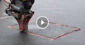 Road Machine Cuts The Asphalt